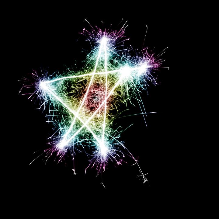 a bright multicolored sparking star symbol on a black background