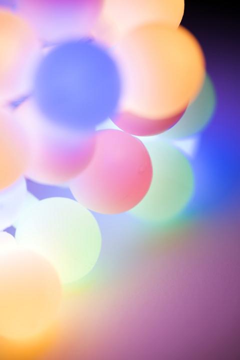 Purple, yellow and pink spheres lit from beneath with copy space as abstract background