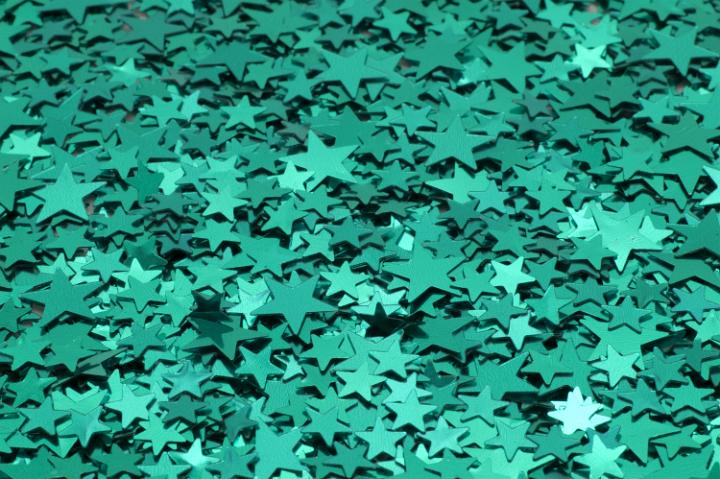 a colorful background of sparkling reflective green metallic stars
