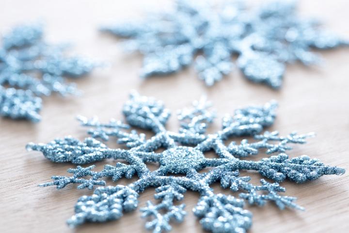 Close up shot of a glittery plastic blue snowflake decoration