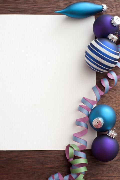 Several Christmas tree balls and festive ribbon lying on white frame. Copy space