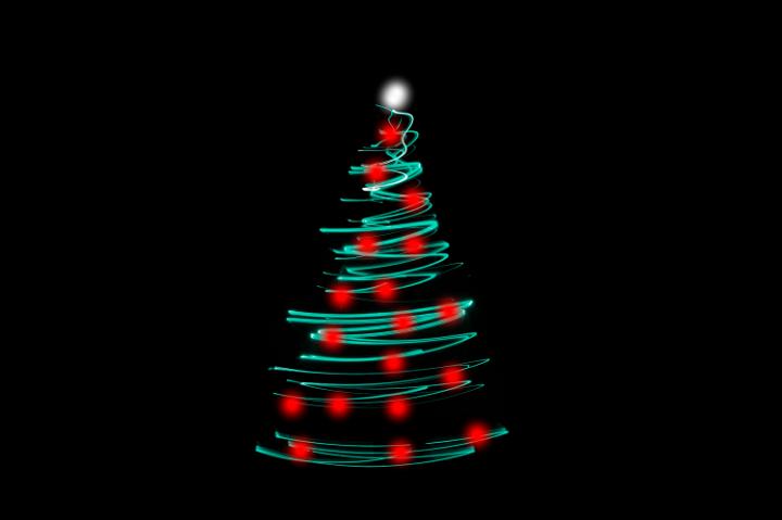 Christmas tree light with a modern abstract zig-zag shape depicting a conical Christmas tree with sparkling tip in traditional red and green on a black background