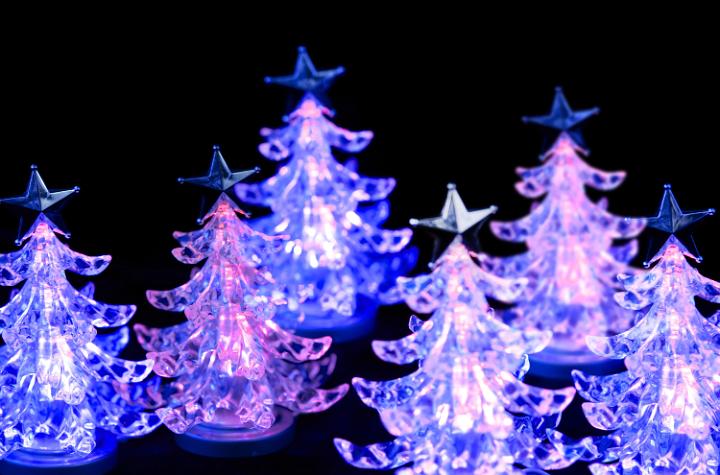 a forest of pink LED christmas trees, glowing on a black background