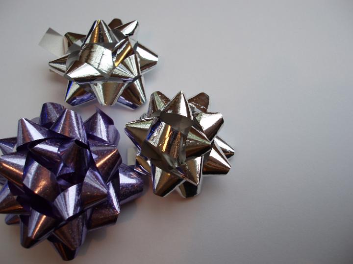 a decorative background of three reflective metalic wrapping bows