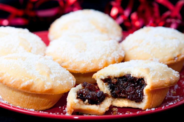 Freshly baked fruity Christmas mince pie broken open to reveal the filling rich in spices and raisins served on a plate for a Christmas teatime