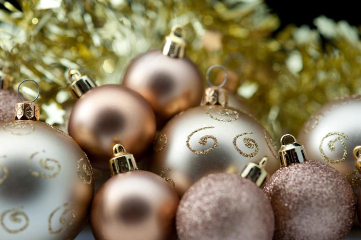 Golden Christmas baubles of various sizes and textures with focus to one with glitter curlicues, copyspace at the top