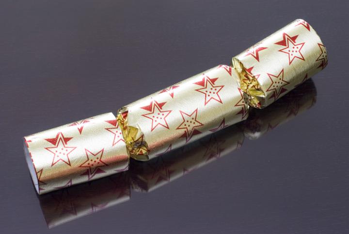 a gold coloured christmas cracker on a dark background