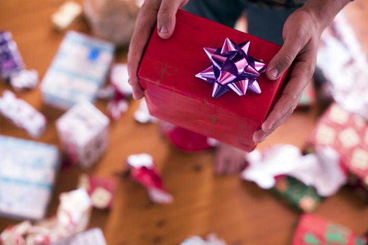 A close up point of view of a young person giving a Christmas Present.