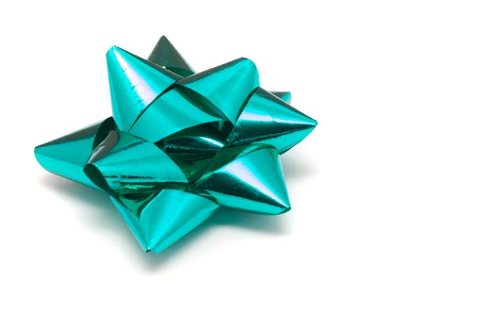 Ornate cyan bow made from metallic foil ribbon for gift wrapping and decorating seasonal and Christmas gifts for loved ones on white with copyspace