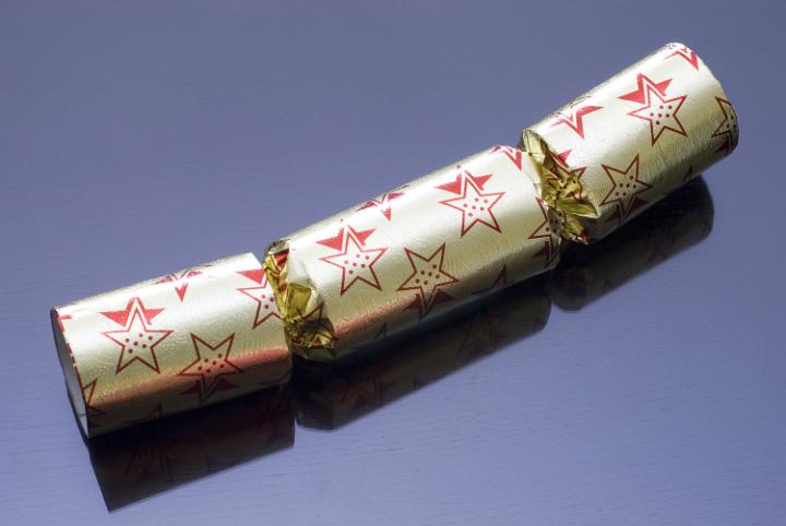 a gold coloured christmas cracker on a dark background