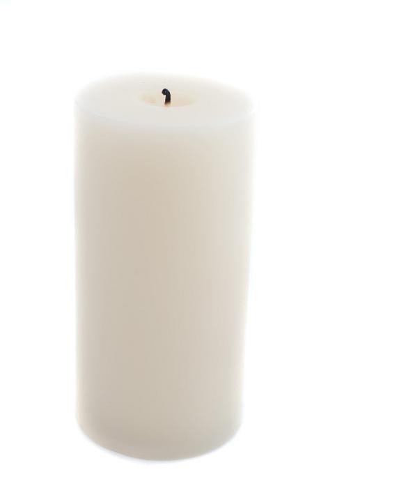a large pillar candle unlit on a white backdrop