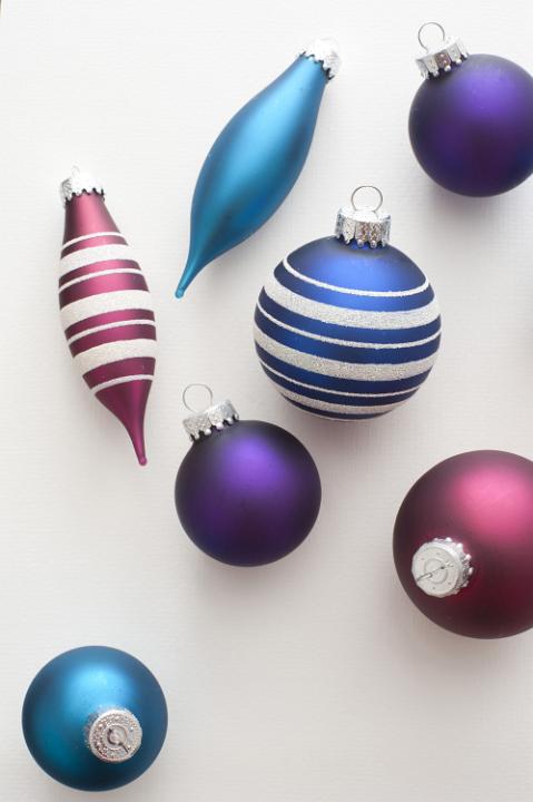 Close-up of seven colorful Christmas balls on white background. From above