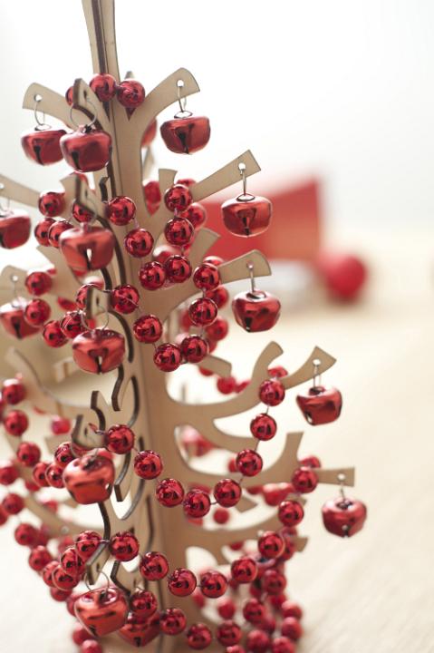 Wooden Christmas tree decorated with bright red bead garland