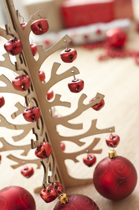 Close-up of wooden Christmas tree decorated with bright red garland
