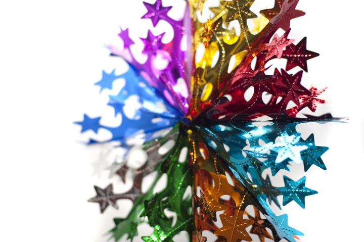 a colorful christmas decoration hanging against a white background, photographed with a narrow depth of field