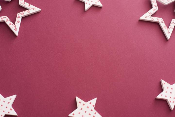 Decorative red and white star border or frame on a crimson background with copy space for your Christmas message