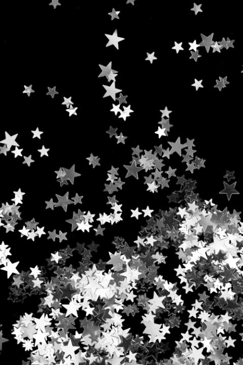 a scattering of silver glitter stars on a black backdrop