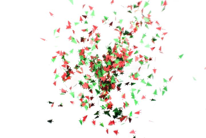 an unusual seasonal image composed of flying christmas tree shaped confetti pieces