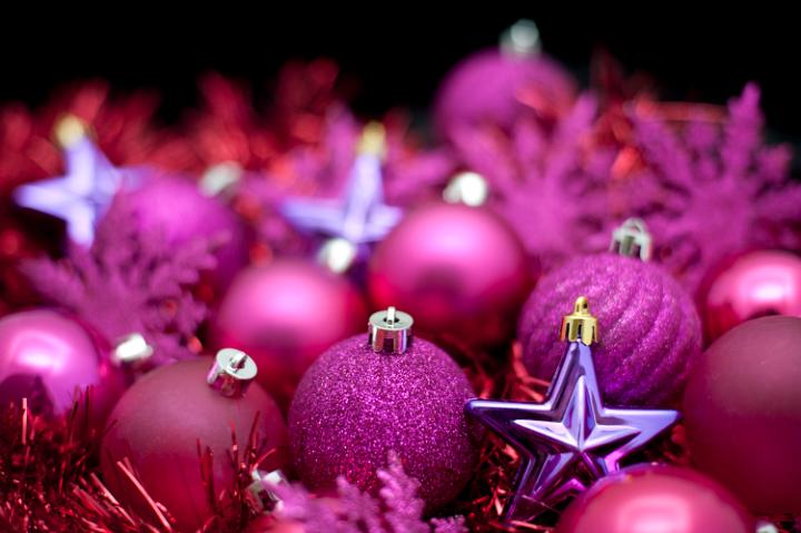 Festive background of purple Christmas decorations, baubles and stars with shallow dof