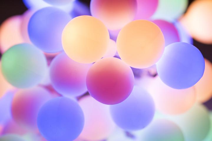 Christmas background of softly glowing colorful round lights in pastel hues in a full frame view
