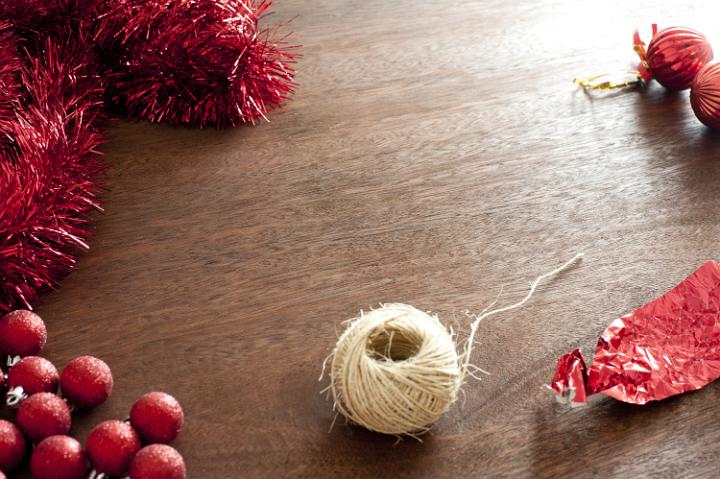 Different Christmas decorative elements on wooden table. Rope, red glare, wrap and Christmas balls