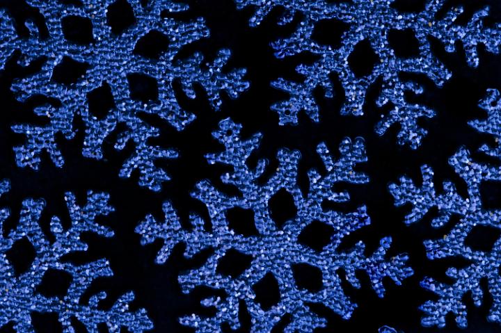blue christmas snowflake shape decorations on a black backdrop