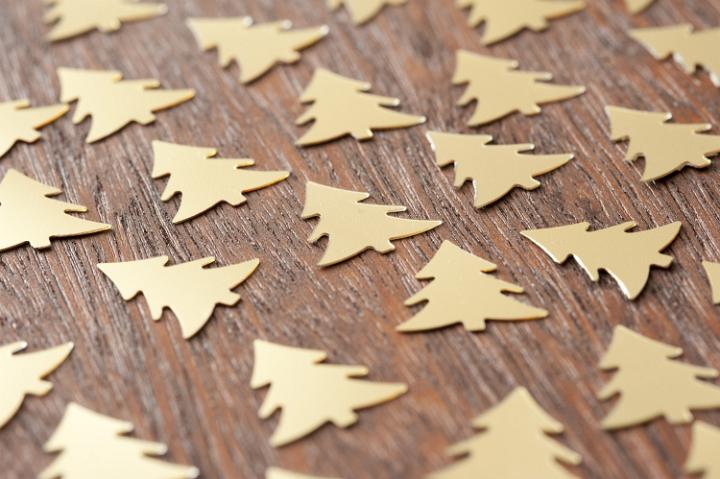 Close-up of small handmade gold Christmas trees on wooden table