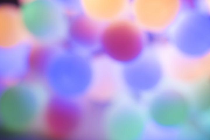 Soft muted Christmas light background with a defocused bokeh of pastel colored round lights with copy space for your seasonal greeting