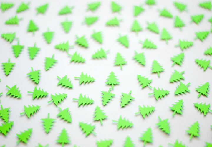 a background of green christmas tree shapes randomly positioned on a white backdrop angled with a narrow depth of field