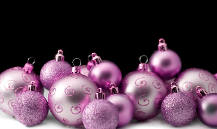 silvery pink christmas bauble ornaments with a space for text on a black background