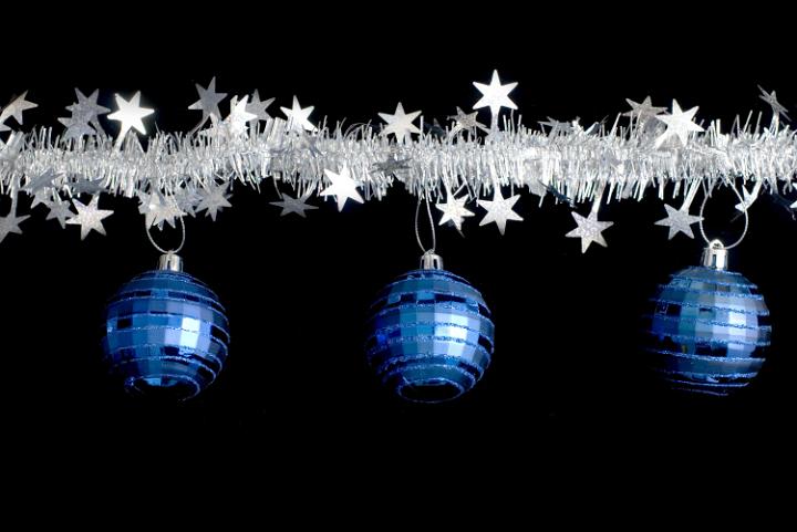a line of christmas tinsel and and three hanging christmas balls
