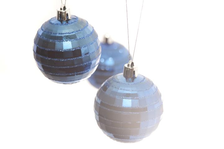 a high-key image of three hanging christmas balls