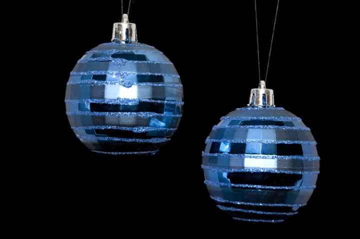 two hanging christmas baubles isolated on a black backdrop