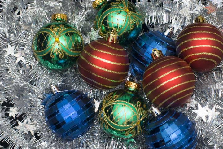 red green and blue christmas baubles on a bed of tinsel makes a colorful christmas backdrop