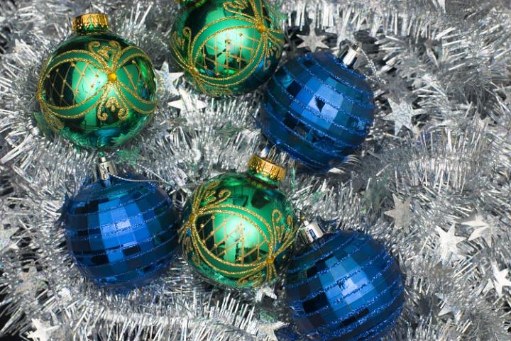 reflective and sparkling christmas balls on a silver tinsel backdrop