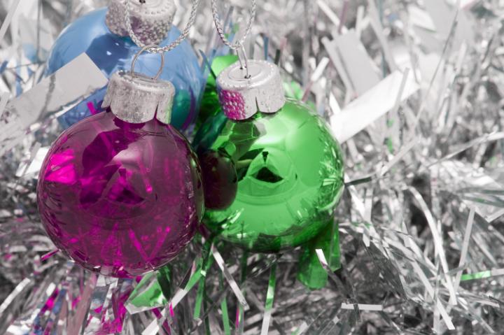 a background of colorful christmas baubles and silver tinsel