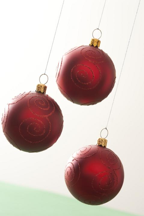 Three red Christmas balls hanging on white background. Isolated