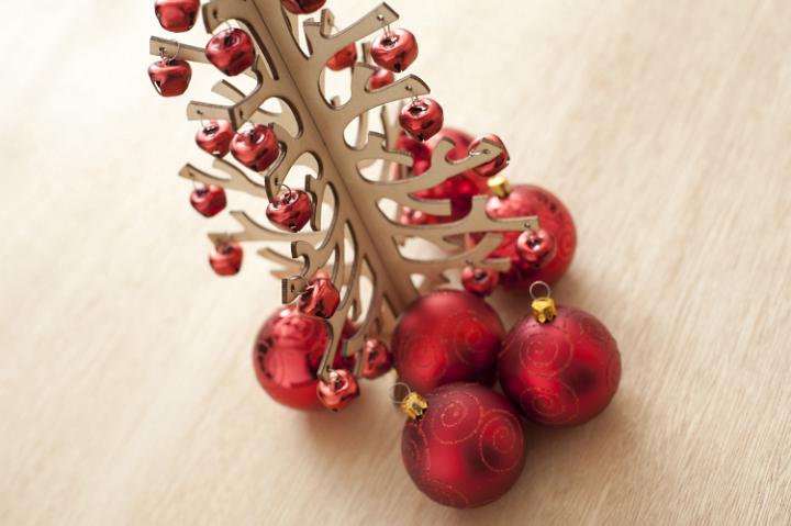 Christmas tree decorated with red festive balls on a modern wooden table