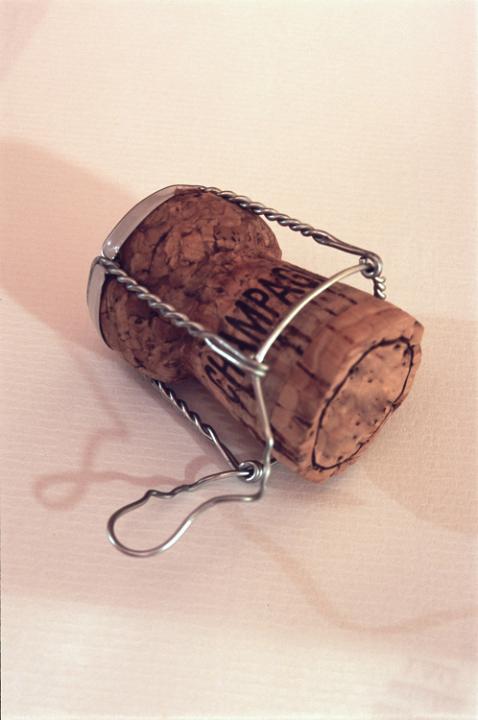 a popped champagne cork and muselet, symbolic of cracking open a bottle of bubbly for a party