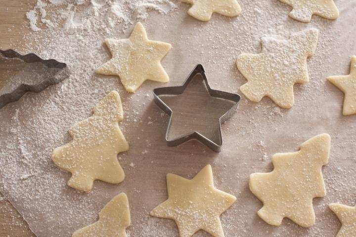 Fresh cookie dough in shapes of Christmas holiday theme stars and trees ready to bake