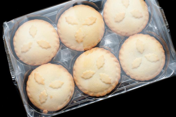 Festive fruity Christmas mince pies in their plastic packaging from the supermarket for a festive seasonal treat, overhead view