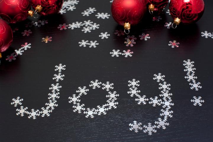 Joy to the world, a Christmas message with the word Joy formed of tiny snowflakes on a dark bqckground