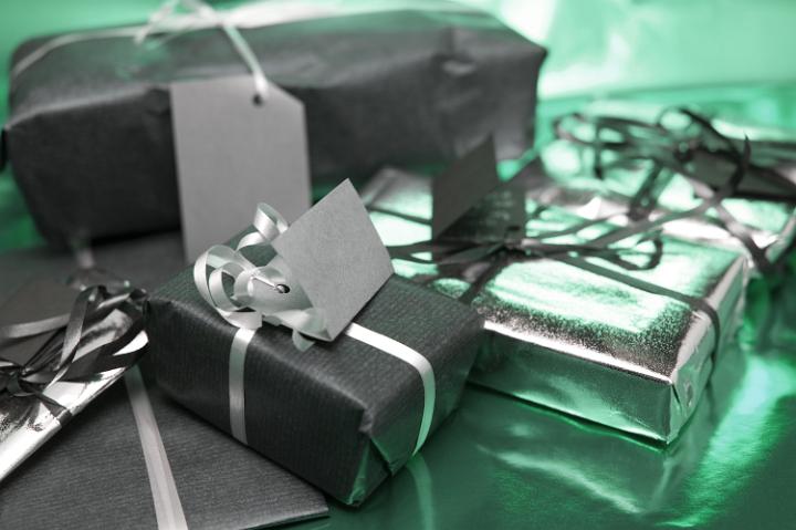 a pile of christmas wrapped gifts on a green metallic reflective background