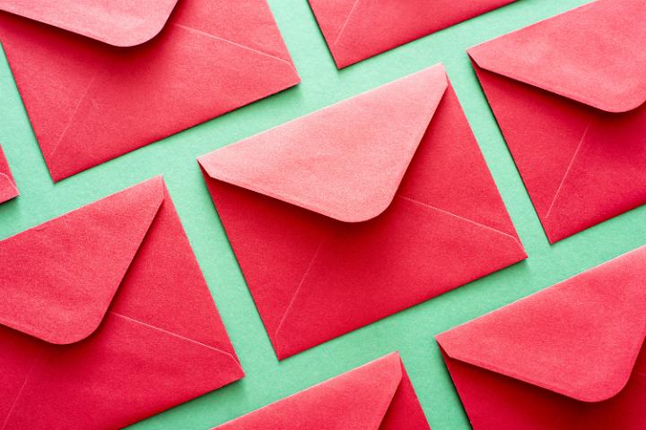 Background pattern of festive red envelopes arranged neatly in rows on a green background for your seasonal Christmas or New Year message