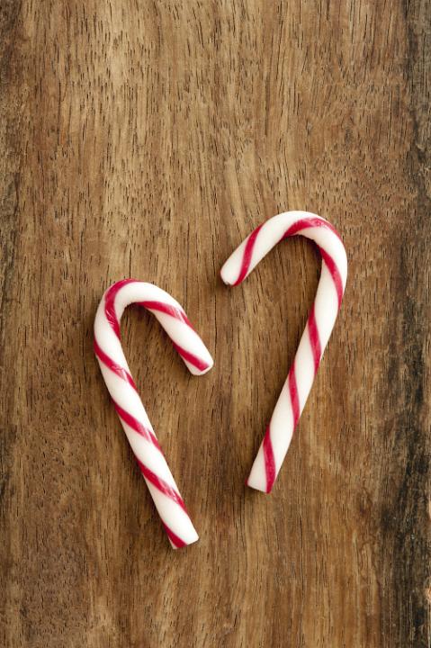 Close-up of two sweet peppermint candycanes on wooden table. From above