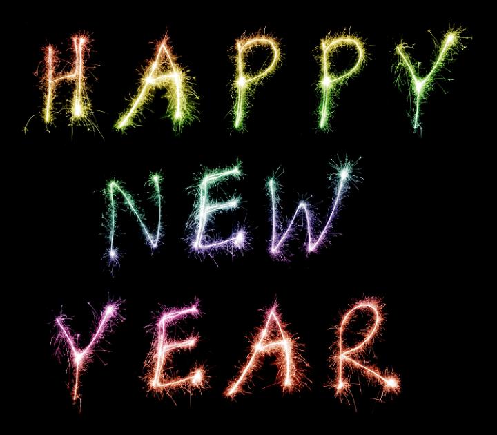 Happy New Year written in colourful multicoloured sparklers on a black background for your greetings and best wishes for a happy season