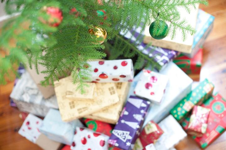 Christmas bounty with a collection of multiple colourful gift-wrapped presents and gifts at the foot of a decorated Christmas tree