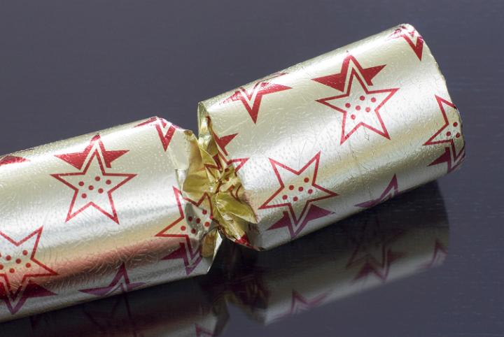 closeup on a gold coloured christmas cracker on a dark background