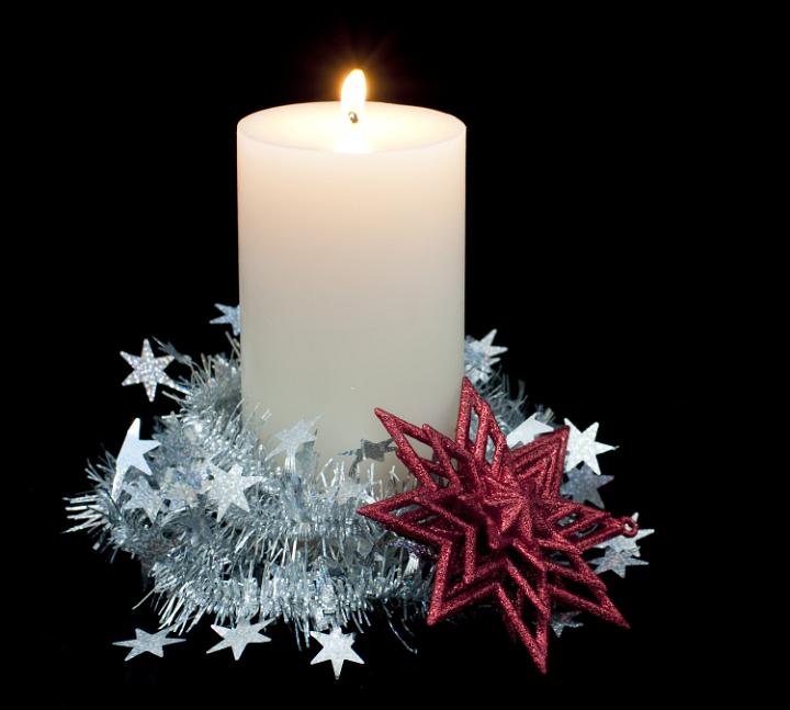 a pillar candle surrounded by festive decorations