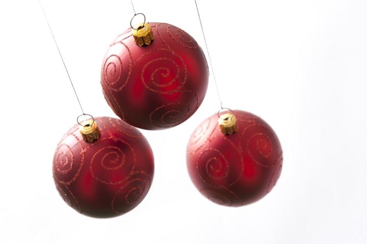 Three red Christmas balls hanging on white background. Isolated